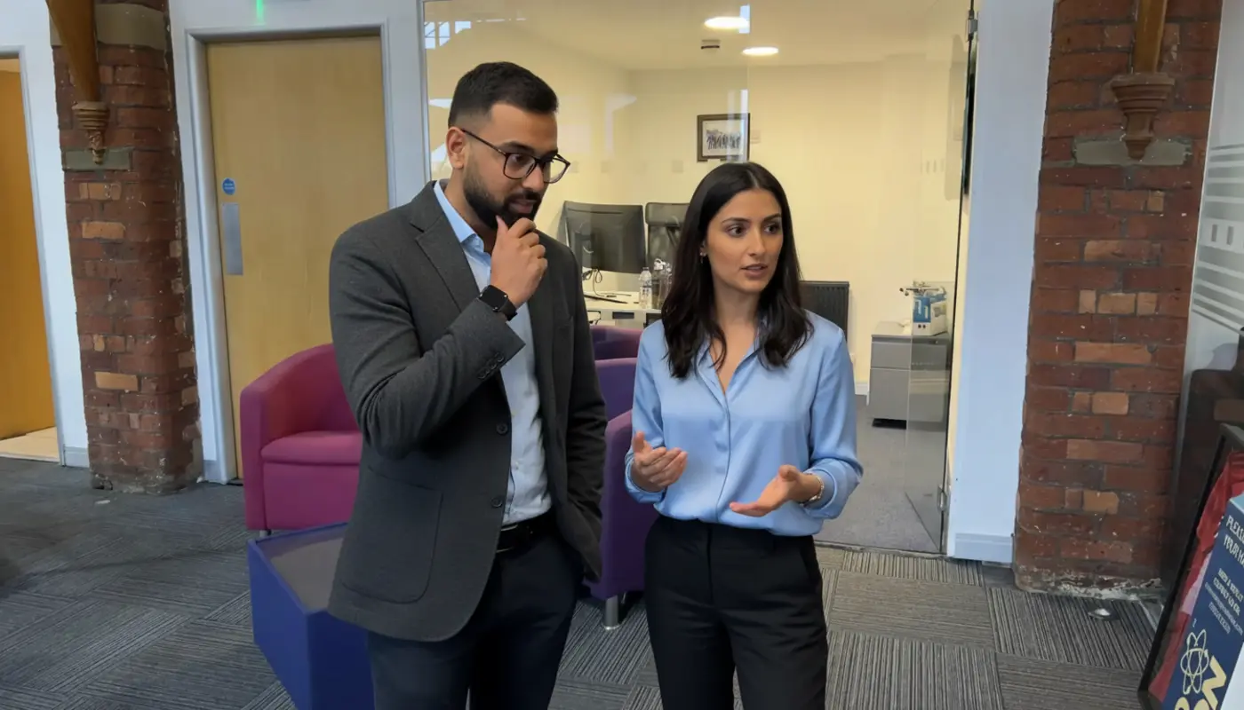 Omar and Sara discussing advanced AI concepts inside a UK office environment.