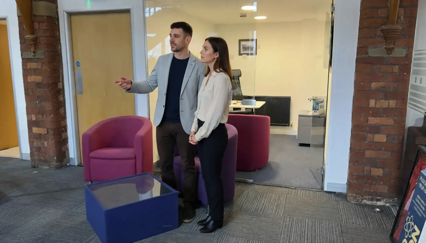 Adam and Jessica discussing imagery graphic design concepts inside a UK creative studio office.