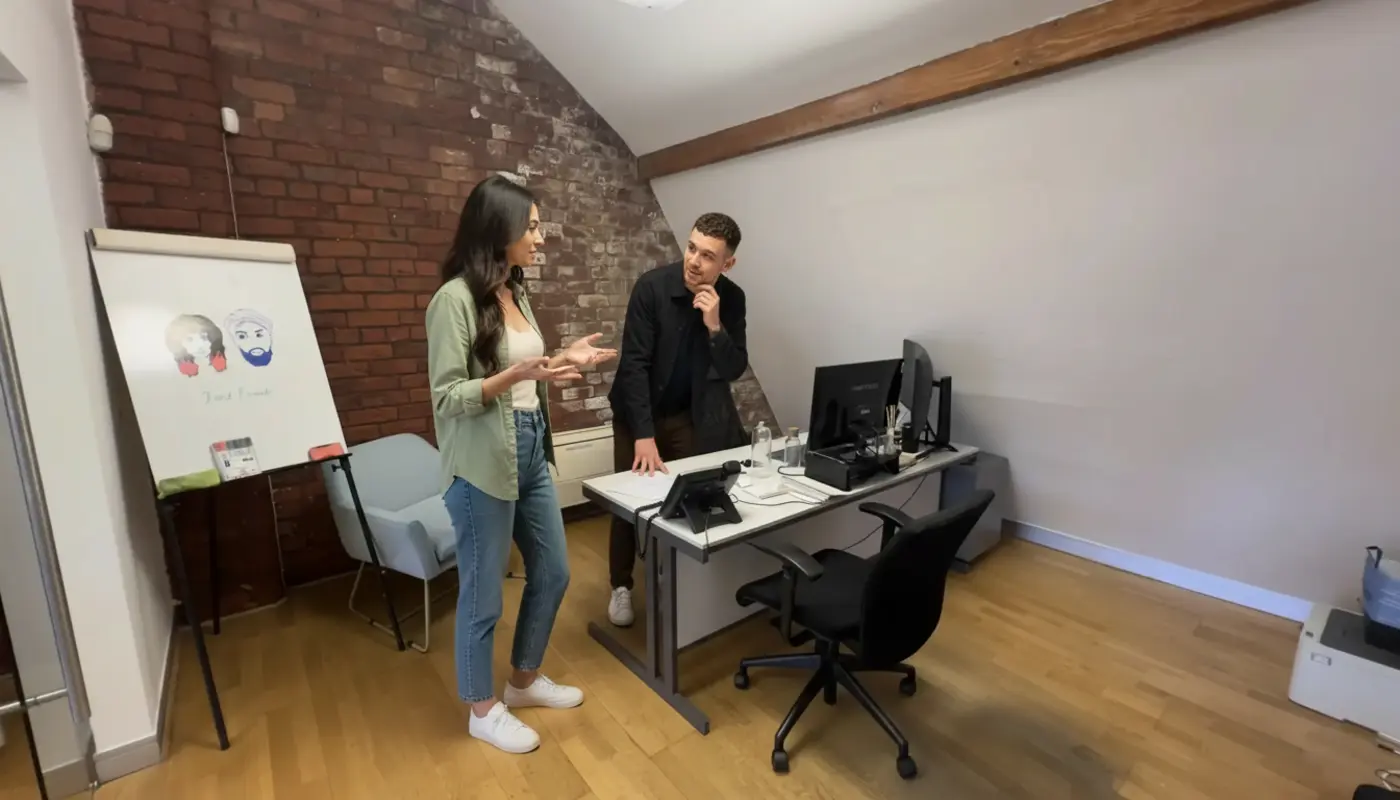 Sara and Adam discuss VoIP versus traditional phone systems in a bright modern office setting.