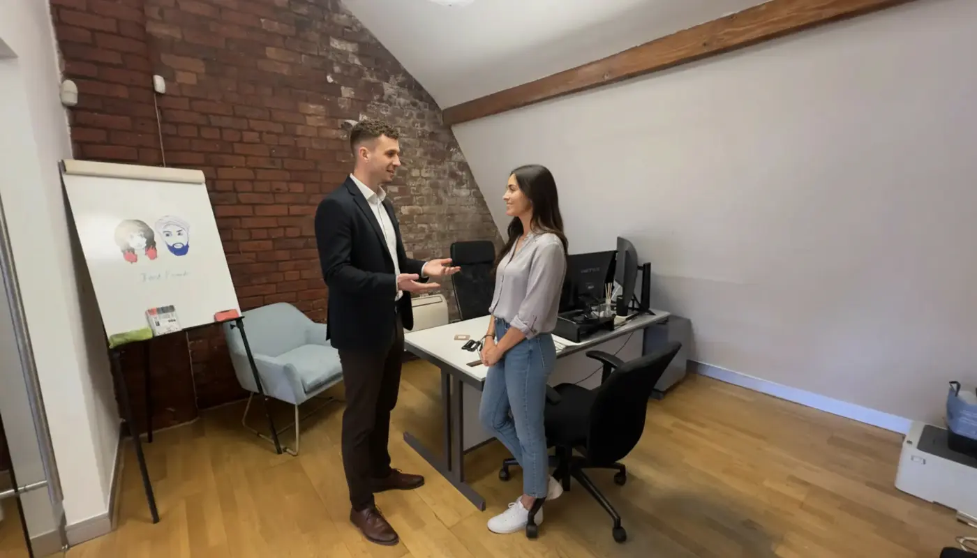 Adam and Sara discussing PPC strategy inside a UK office.