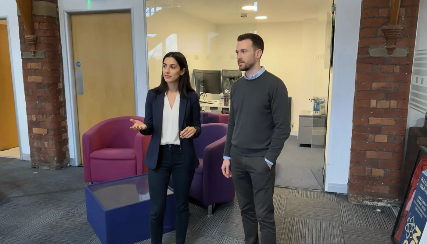 Sara and Adam discussing voice AI inside a UK office, mid-collaboration.