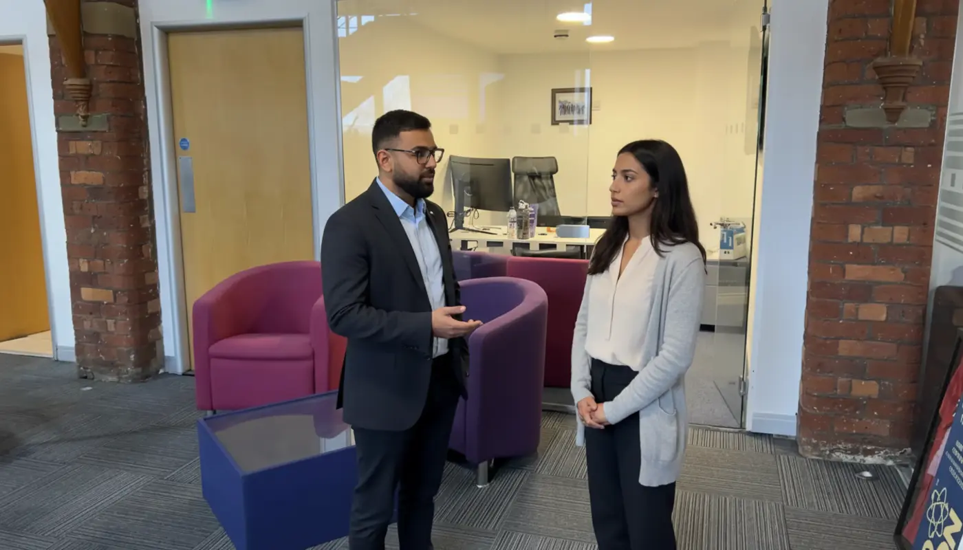 Omar and Sara discussing AI search visibility strategy inside a UK office.