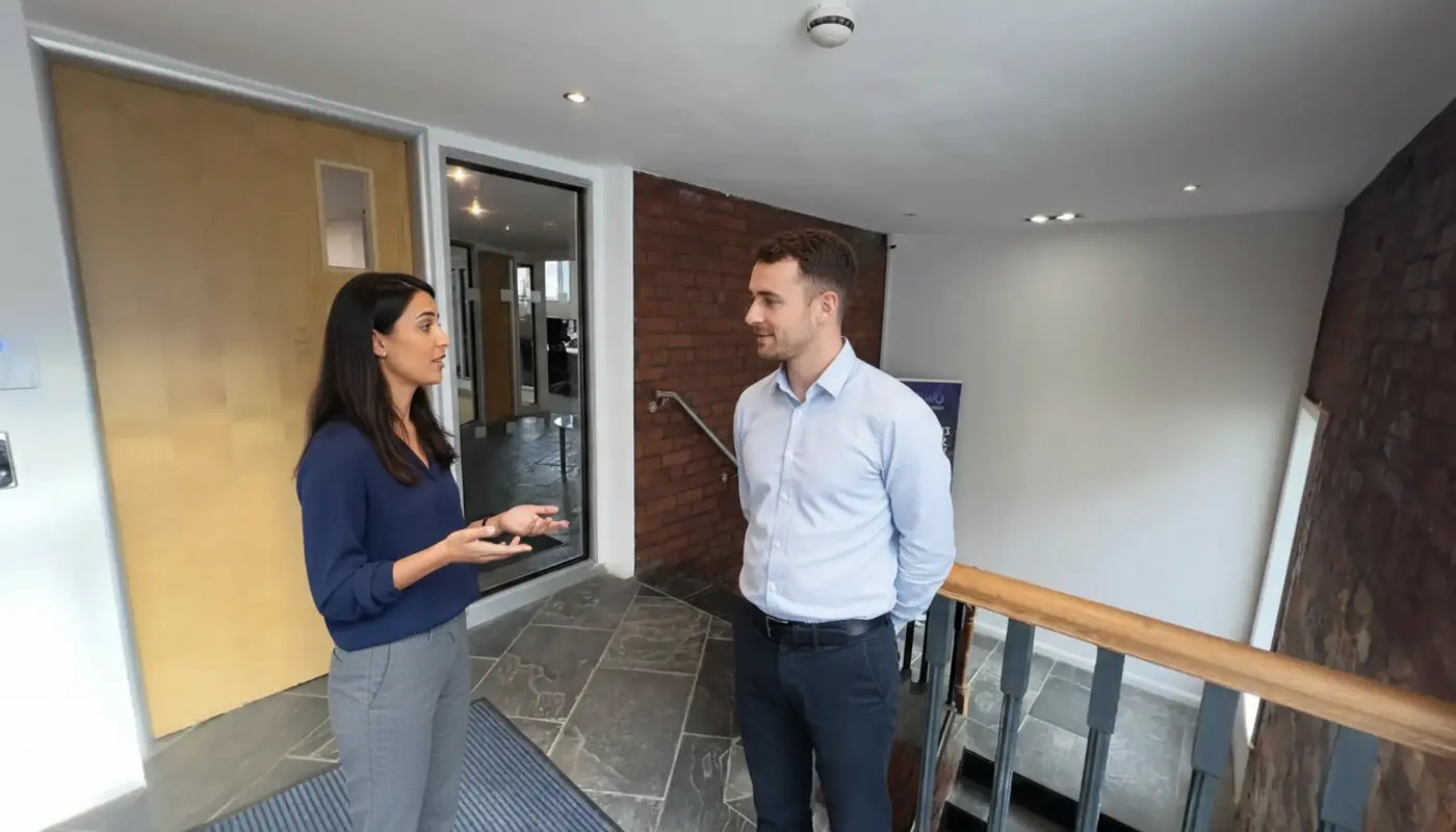 Sara and Adam discussing branding inside a UK office during a natural collaborative moment.