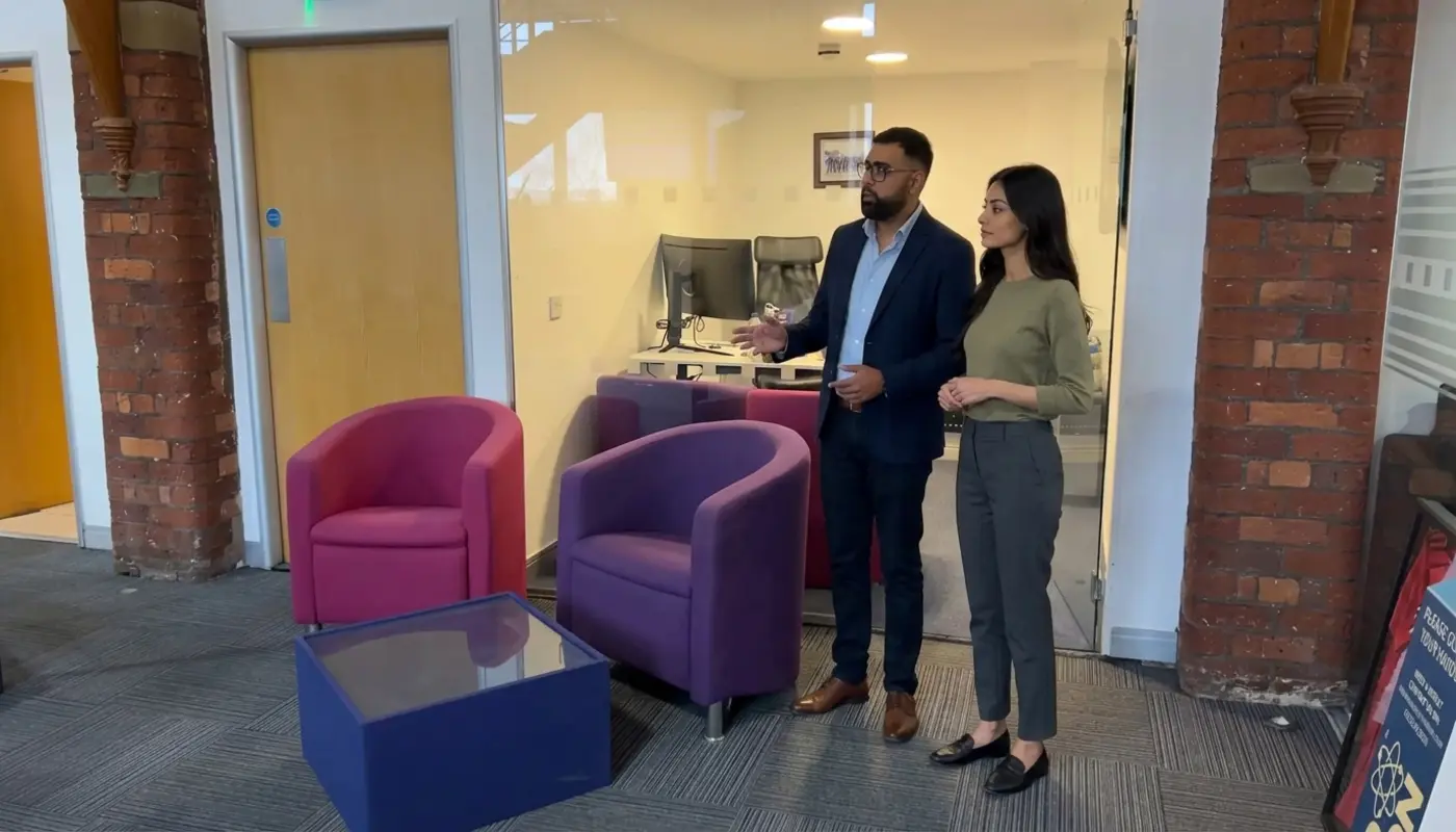 Two colleagues discuss Google advertising strategy while standing in a modern office workspace.