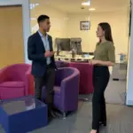 Two colleagues discuss ecommerce launch planning while standing in a Cleartwo office.