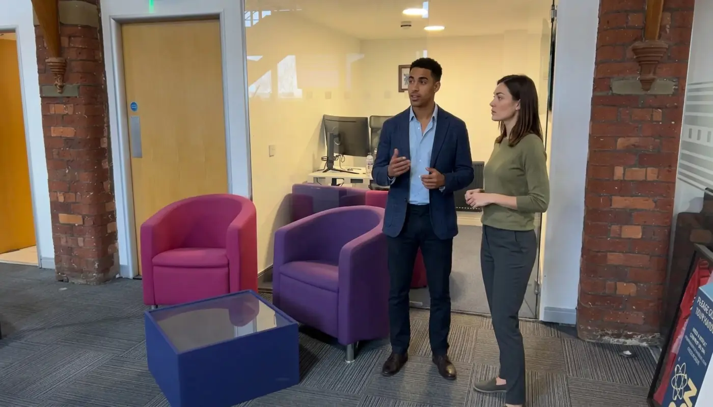 Two colleagues discuss email campaign strategy in a modern office during a focused planning session.