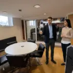 Two colleagues discuss an Office 365 setup walkthrough while standing naturally in a UK office workspace.