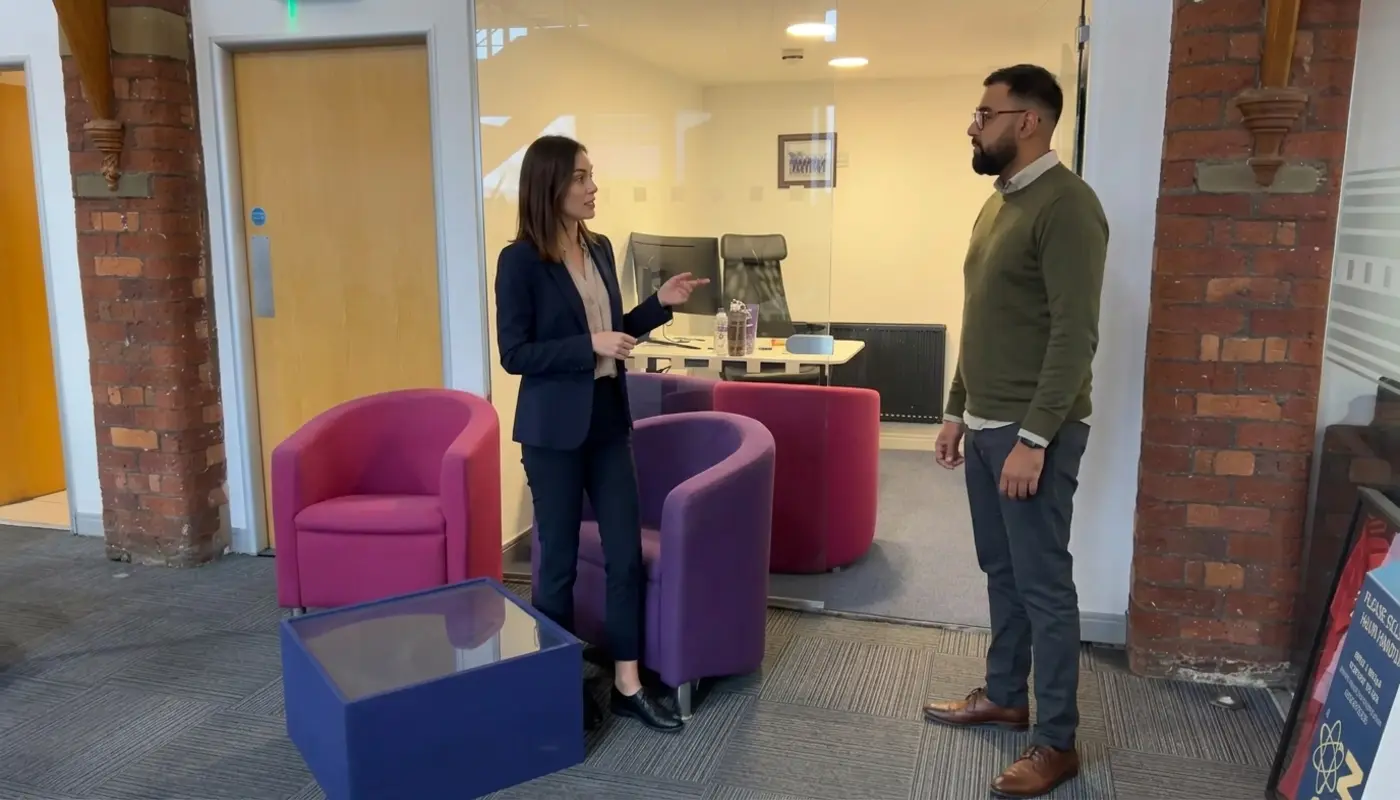 Two professionals discuss search marketing strategy while standing in a modern office workspace.