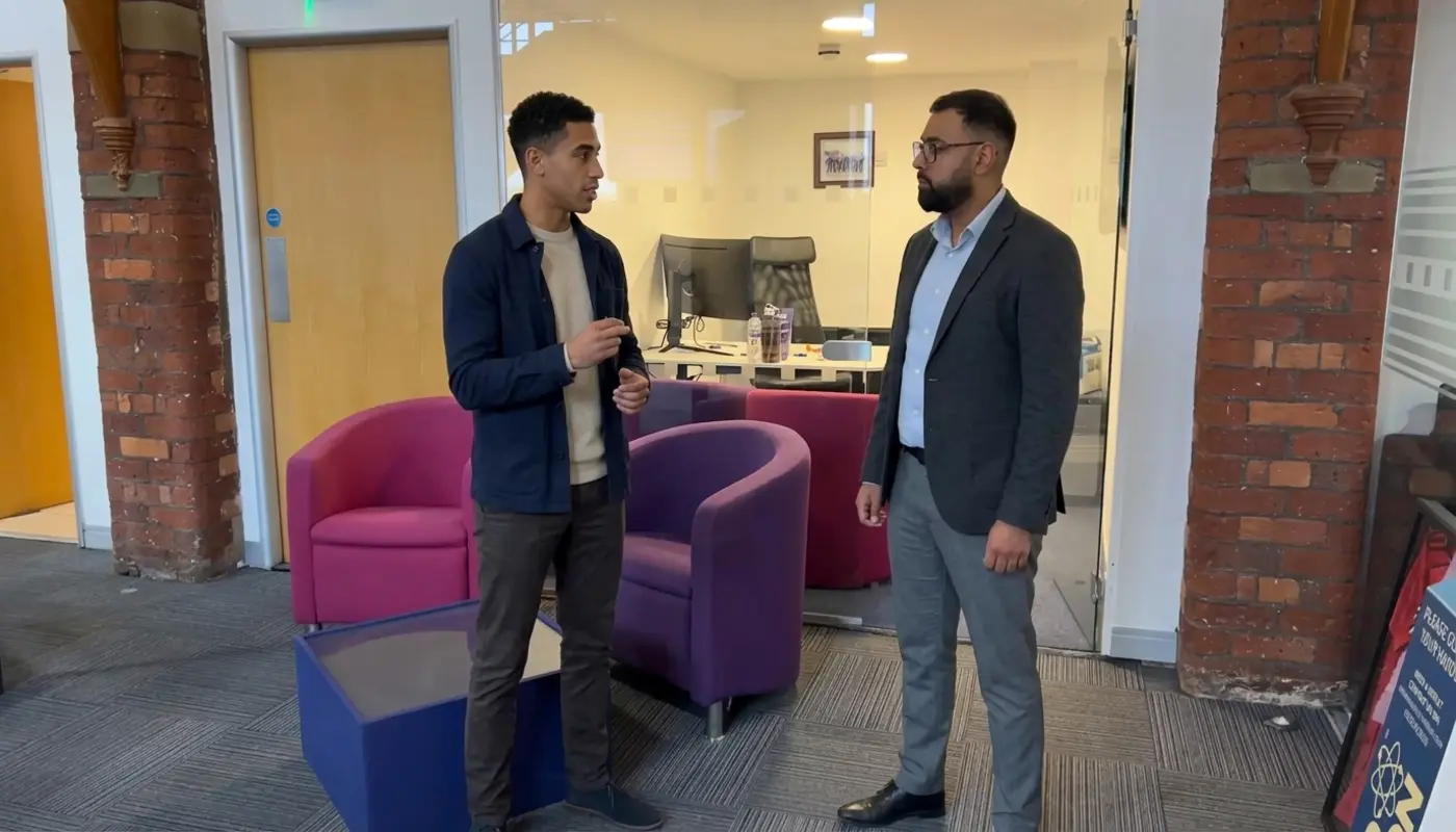 Two professionals discuss CRM strategy in a modern office during a focused working conversation.
