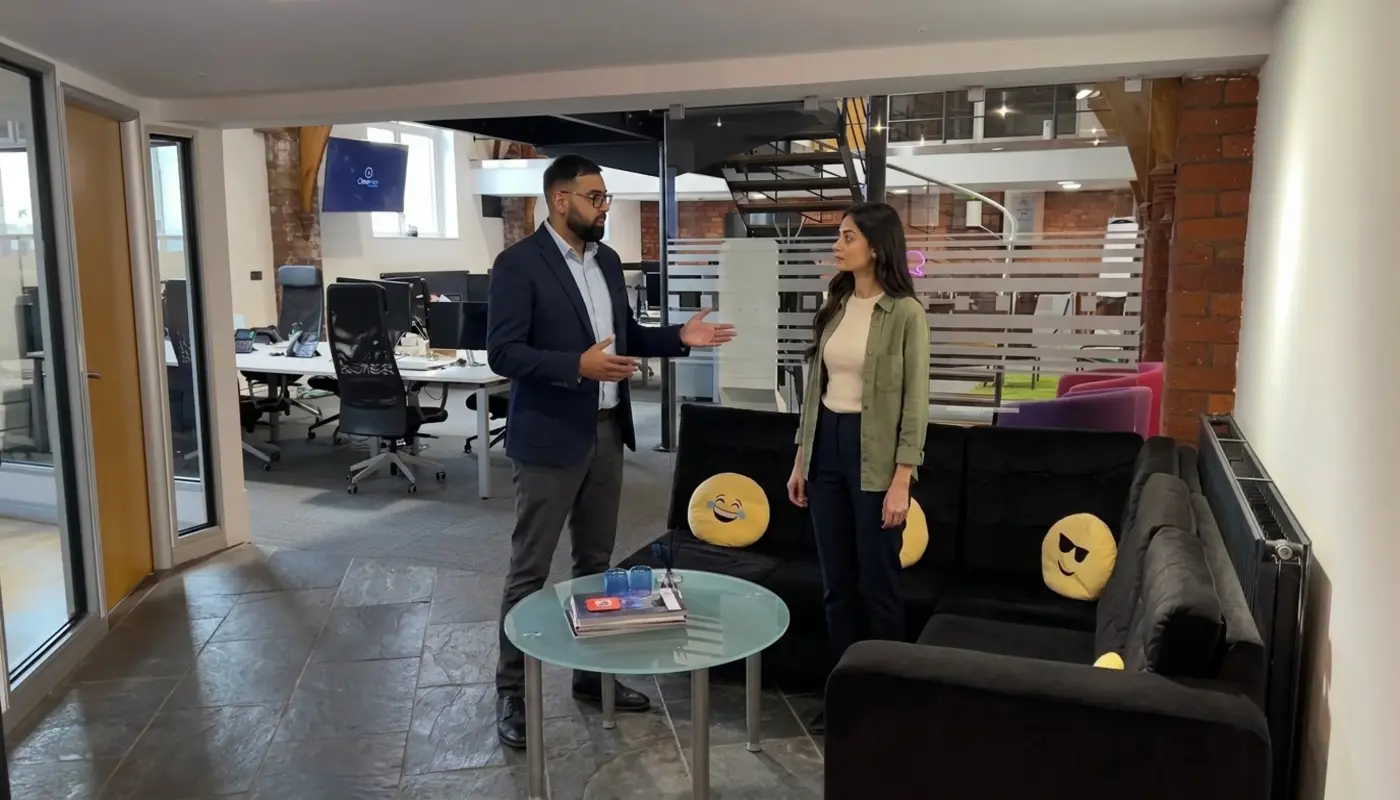 Two colleagues discuss an AI workflow while walking through a UK office.