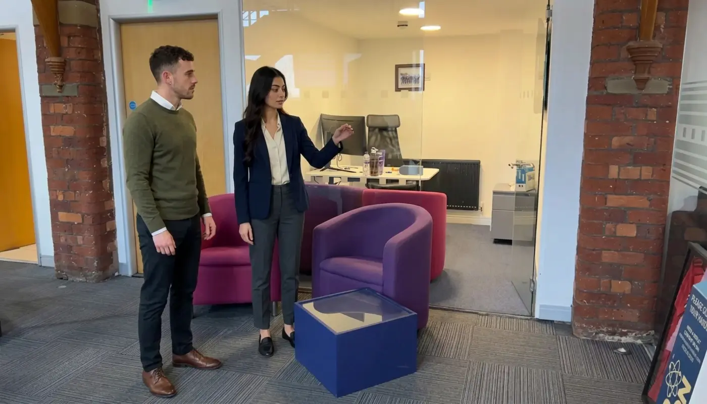 Two colleagues discuss an AI website plan in an office while reviewing the next steps together.