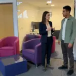 Two colleagues in an office discuss brand identity ideas while planning the first stage of a logo project.