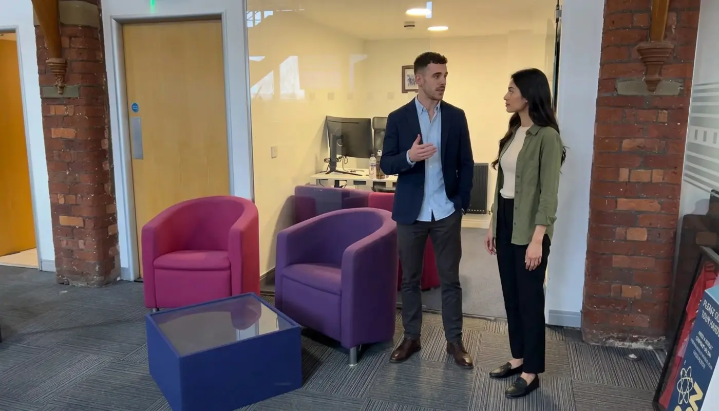 Two colleagues discuss social media audience planning in a modern office.