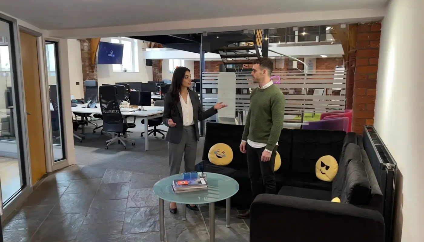 Two colleagues discuss a digital marketing plan in an office while reviewing the next client growth steps.