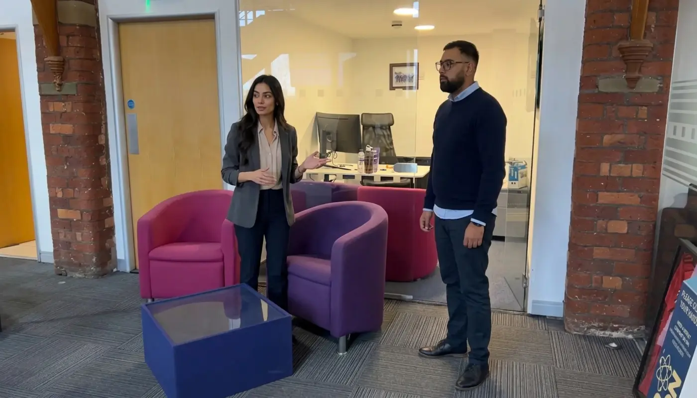 Two professionals discuss agency planning in a modern office with natural body language and focused collaboration.