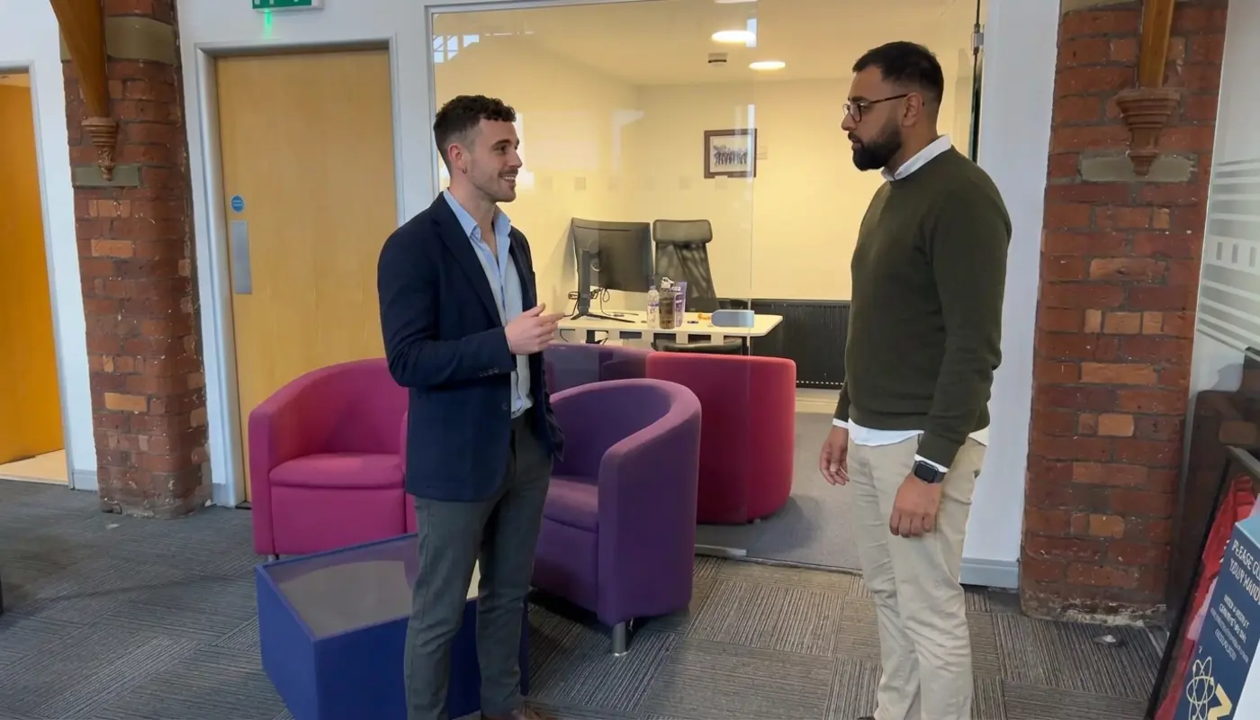 Two professionals discuss client process organisation in a modern office during a working conversation.