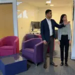 Two colleagues discuss a proposed digital signage position in a UK office.