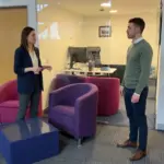 Two colleagues discuss managed IT coverage during an office walkthrough.