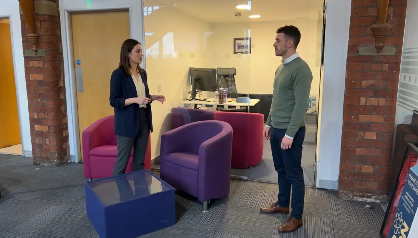 Two colleagues discuss managed IT coverage during an office walkthrough.