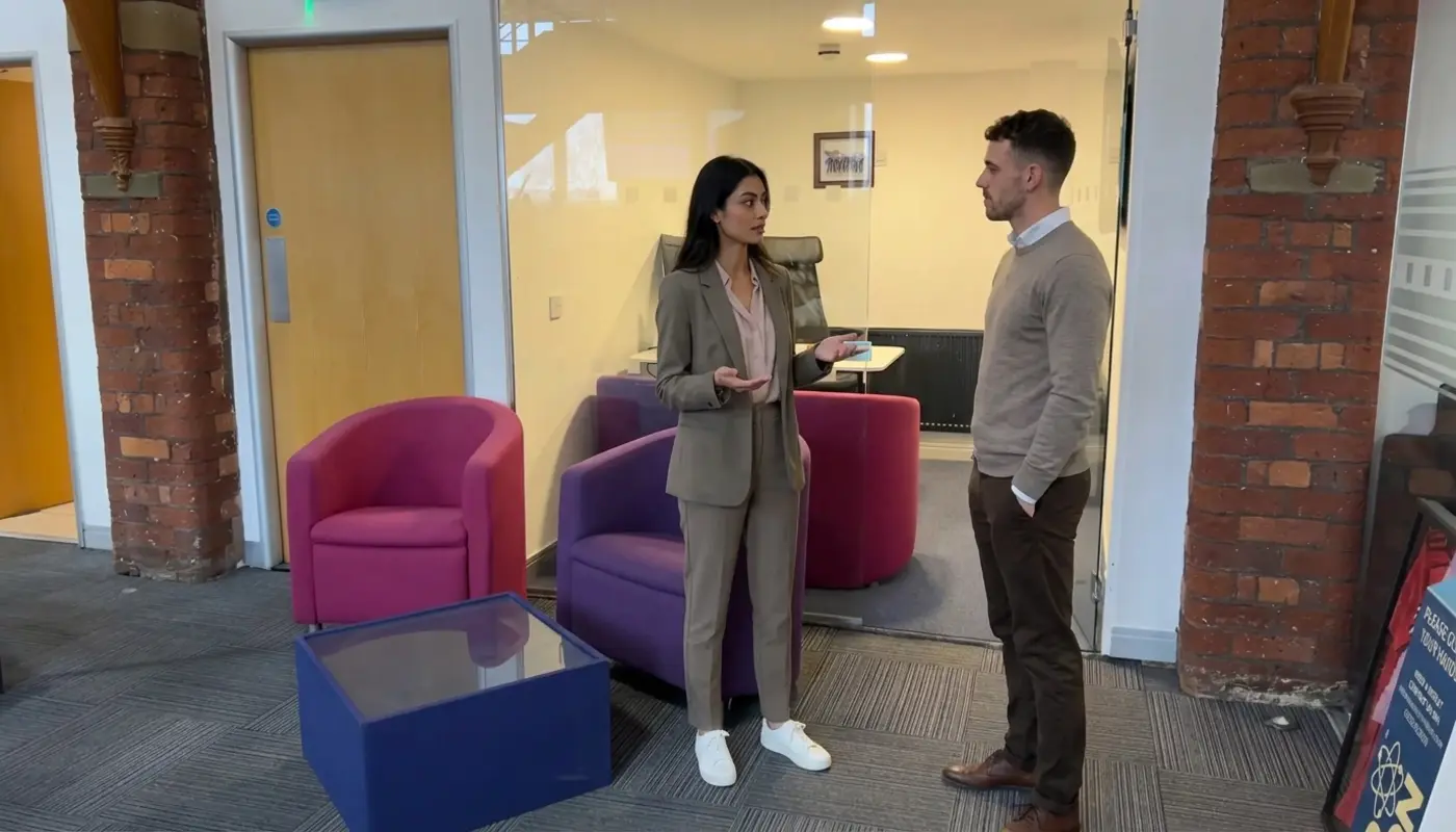 Two colleagues discuss marketing direction while standing in a Cleartwo office during a strategy meeting.