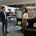 Two professionals walk through an office discussing a startup IT support setup.