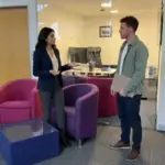 Two colleagues discuss individual seller setup steps during an ecommerce planning session in a UK office.