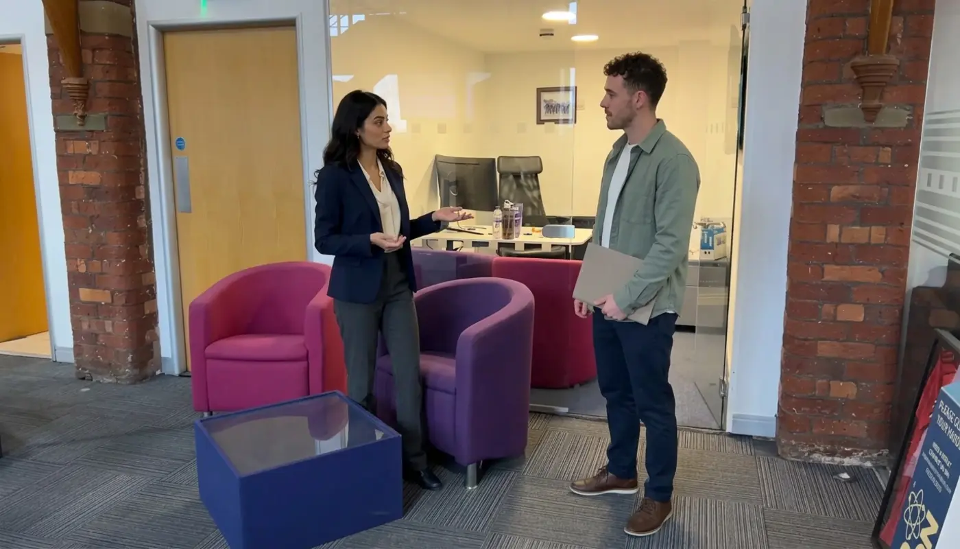 Two colleagues discuss individual seller setup steps during an ecommerce planning session in a UK office.