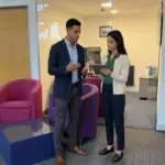Two colleagues review an online shopping flow on a tablet in a UK office.