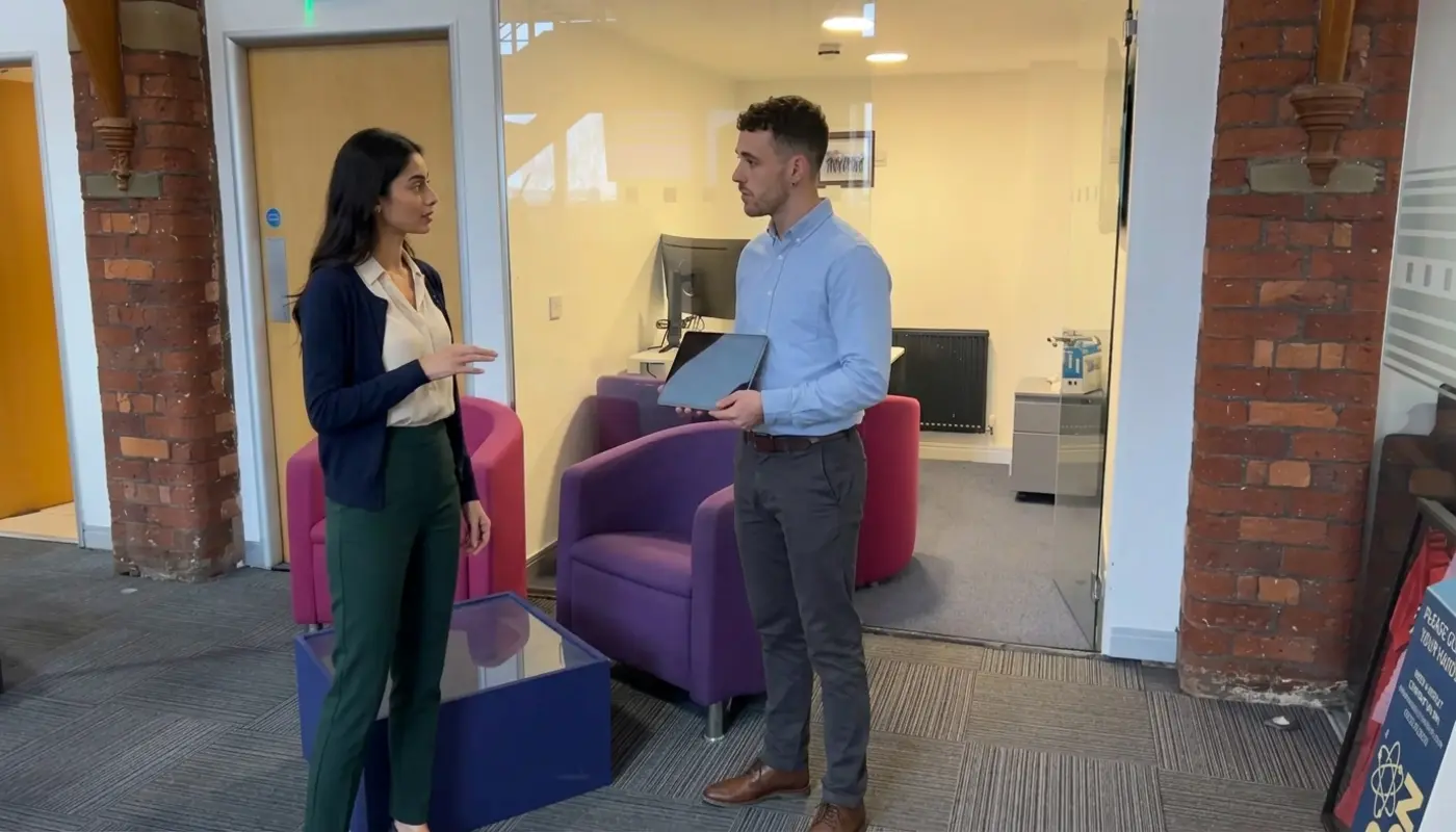 Two colleagues discuss ecommerce store setup in a UK office during a practical planning session.
