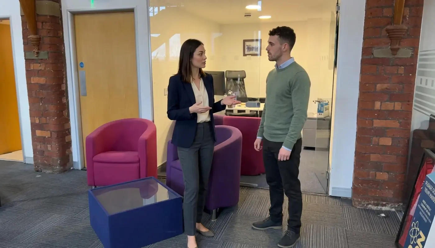 Two colleagues discuss WordPress SEO keyword placement in a modern office setting.