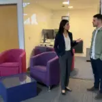 Two colleagues discuss Shopify store planning in a UK office during a focused working conversation.