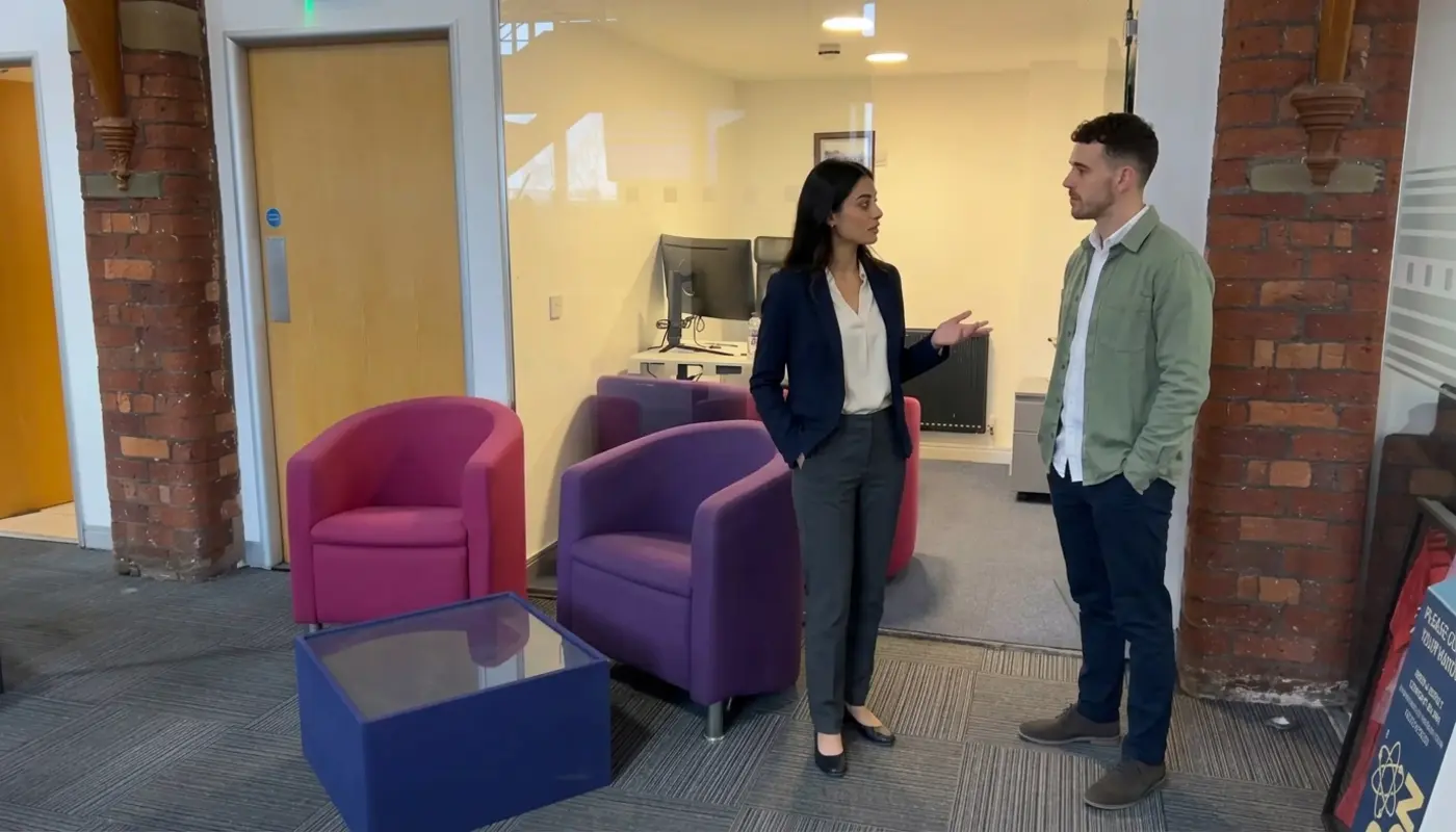 Two colleagues discuss Shopify store planning in a UK office during a focused working conversation.
