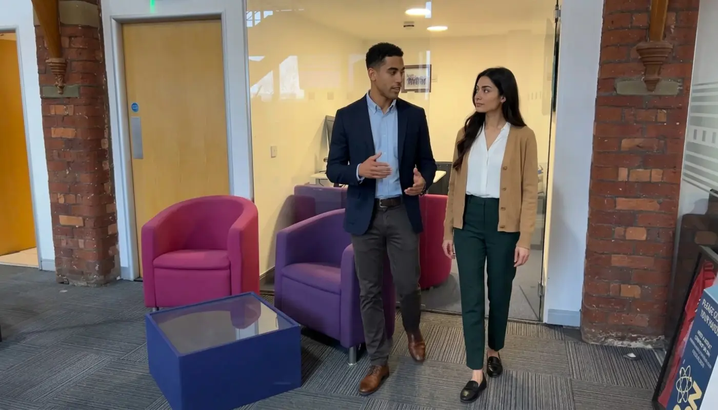 Two colleagues discuss CRM workflow needs while walking through a modern office.