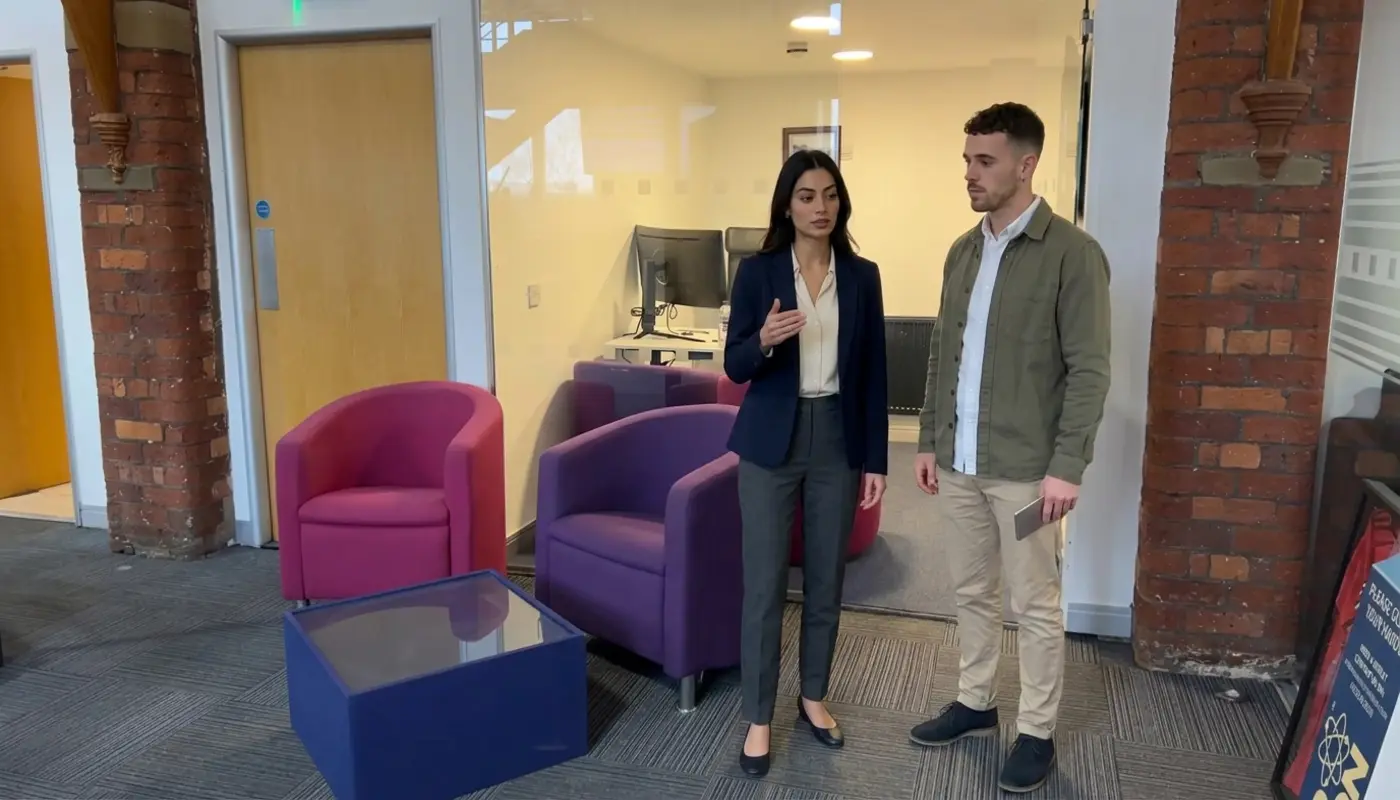 Two colleagues discuss Facebook audience planning while standing in a modern office setting.