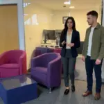 Two colleagues discuss brand content strategy while walking through a UK office.