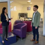 Two colleagues discuss a social media growth plan while standing in a UK office.