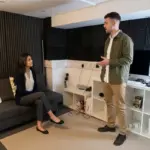 Two colleagues discuss recruitment CRM planning in a small office consultation setting.