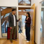 Two colleagues in a modern office compare a phone while discussing TikTok search privacy