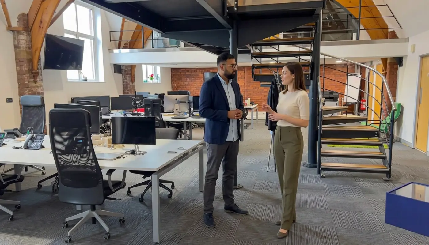 Two colleagues discuss generative search strategy while standing in a modern office setting.