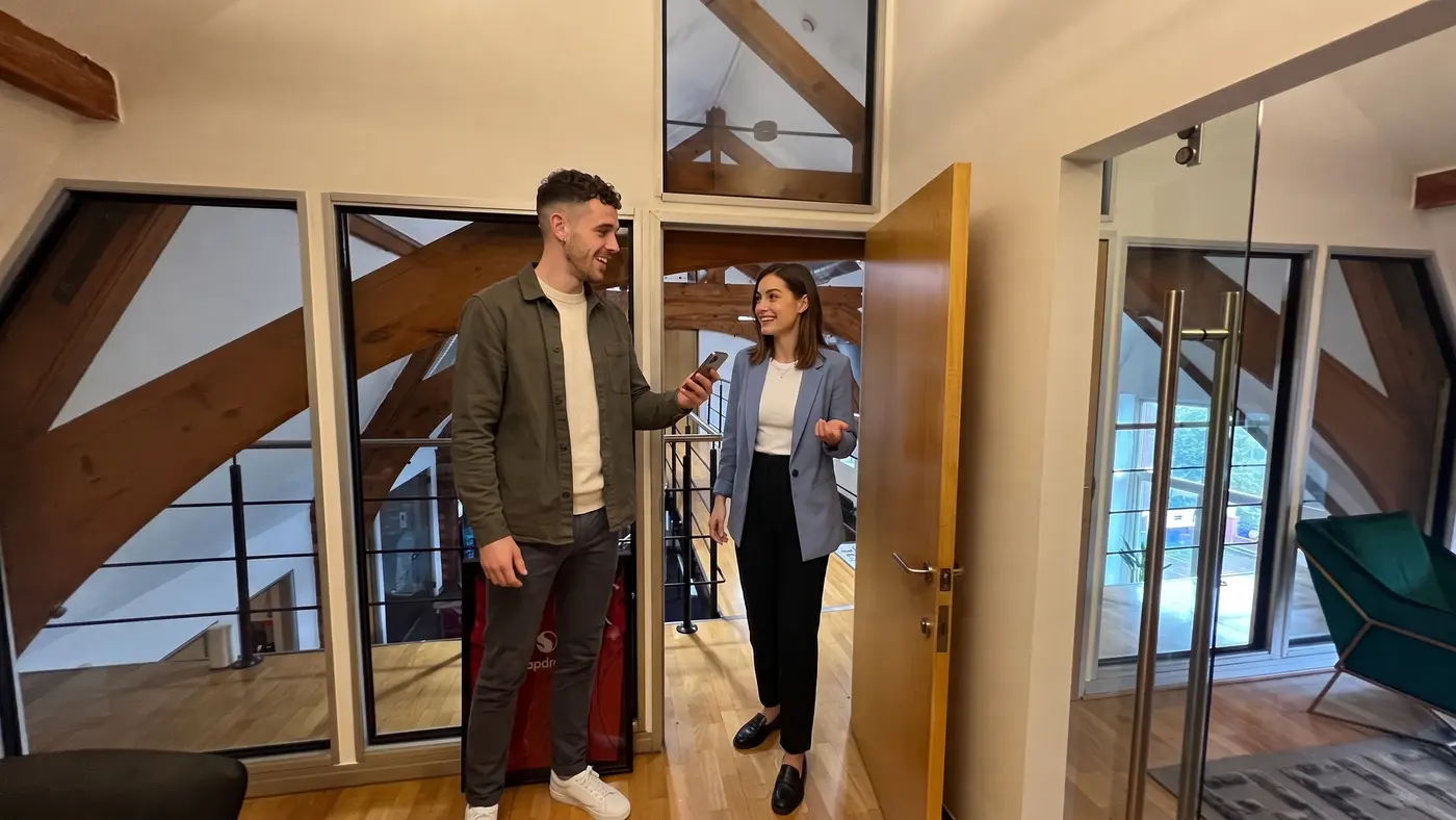 Two colleagues in a modern office check a phone while discussing TikTok LIVE access.
