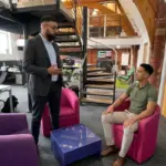 Two colleagues discuss a TikTok sales strategy in an open-plan office seating area.