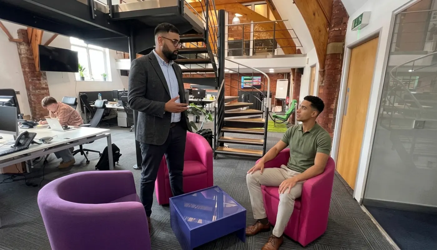 Two colleagues discuss a TikTok sales strategy in an open-plan office seating area.