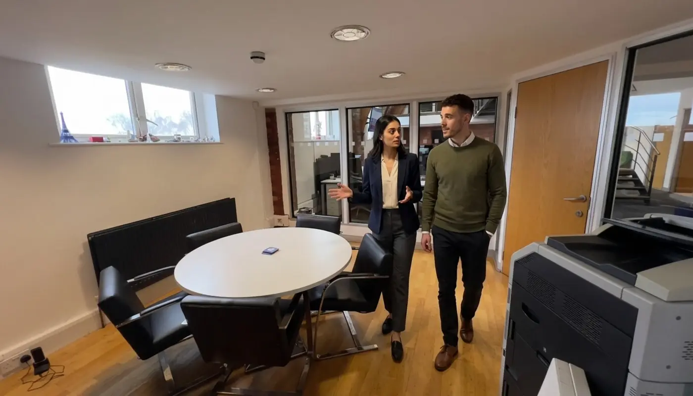 Two professionals discuss connected CRM workflows while walking through a modern office.