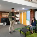 Two colleagues discuss AI automation opportunities in a modern office during a professional walkthrough.