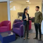 Two colleagues discuss ecommerce consulting priorities in a UK office during a store audit planning session.