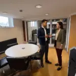 Two colleagues discuss logo design choices in an office during a brand identity consultation.