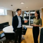 Two colleagues review an ecommerce setup process at a meeting table in a modern office.
